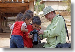 asia, asian, cameras, childrens, clothes, emotions, groups, hats, horizontal, laos, men, people, river village, showing, smiles, tourists, villages, photograph