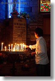 asia, asian, candles, catholic, glow, lights, men, neon, people, saigon, vertical, vietnam, photograph