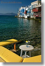 benches, buildings, europe, facing, flowers, greece, mykonos, vertical, water, yellow, photograph
