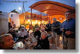 cafes, clothes, dusk, europe, glasses, greece, groups, horizontal, men, people, tourists, photograph