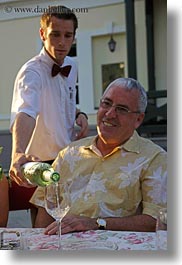 clothes, colors, emotions, europe, foods, glasses, groups, happy, hungary, men, ofer ben tov, people, pouring, senior citizen, smiles, vertical, waiter, white wine, wine glass, wines, yellow, photograph