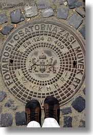 budapest, clothes, cobblestones, covers, europe, feet, hungary, irons, manhole covers, manholes, materials, shoes, vertical, photograph