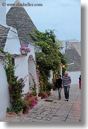 alberobello, buildings, couples, europe, flowers, italy, people, puglia, structures, trullis, vertical, photograph