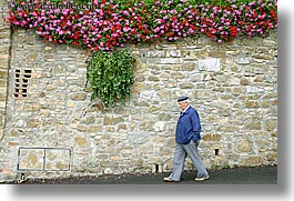 europe, flowers, horizontal, italy, men, montalcino, stones, towns, tuscany, walk, walls, photograph