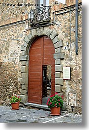 archways, doors, europe, flowers, geraniums, italy, montalcino, stones, towns, tuscany, vertical, woods, photograph