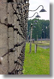 auschwitz, barbed, barbed wire, buildings, europe, fences, grass, lights, poland, prison, prison camp, structures, vertical, wires, photograph