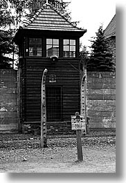 arts, auschwitz, barbed wire, black and white, buildings, design, europe, fences, guard tower, halt, poland, prison, prison camp, signs, structures, towers, vertical, photograph