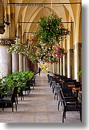 archways, buildings, chairs, europe, flowers, halls, krakow, poland, structures, vertical, photograph