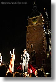 actors, bell towers, bowing, buildings, clock tower, crowds, europe, krakow, nite, people, performance, poland, structures, vertical, photograph