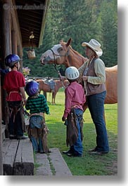 america, childrens, clothes, cowboy hat, hats, helmets, horses, idaho, looking, north america, people, red horse mountain ranch, stables, united states, vertical, photograph