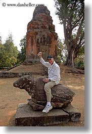 asia, bakong, cambodia, cows, men, stones, vertical, photograph