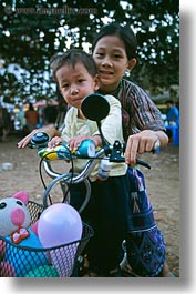 asia, childrens, emotions, girls, laos, luang prabang, motorcycles, people, smiles, vertical, photograph