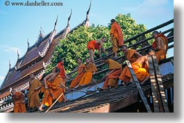 asia, asian, buildings, colors, horizontal, laos, luang prabang, men, monks, oranges, people, roofs, photograph
