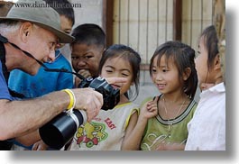 asia, asian, cameras, childrens, clothes, emotions, groups, hats, horizontal, laos, laugh, men, people, river village, showing, smiles, tourists, villages, photograph