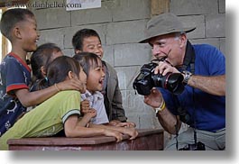 asia, asian, cameras, childrens, clothes, emotions, groups, hats, horizontal, laos, laugh, men, people, river village, showing, smiles, tourists, villages, photograph