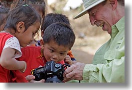 asia, asian, cameras, childrens, clothes, emotions, groups, hats, horizontal, laos, men, people, river village, showing, smiles, tourists, villages, photograph