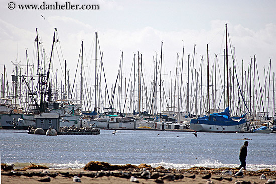 man-walking-on-beach-w-sailboats.jpg