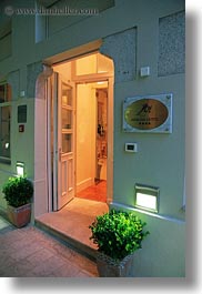 arbiana hotel, arches, croatia, dusk, entry, europe, green, illuminated, rab, shrubs, vertical, photograph
