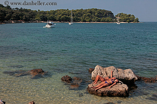 women-sunbathing-on-rocks-by-water-2.jpg