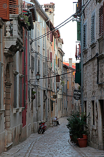 man-sitting-by-motorcycle-on-narrow-street-1.jpg