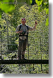 bridge, cameras, clothes, colors, europe, forests, france, green, groups, hats, helanie howard greene, howard, men, nature, people, plants, provence, structures, swing bridge, trees, vertical, photograph