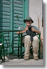 artists, cameras, chairs, clothes, emotions, europe, greece, green, happy, hats, howard, men, people, photographers, senior citizen, sunglasses, tourists, vertical, photograph