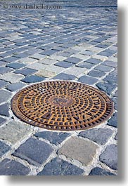 budapest, cobblestones, covers, europe, hungary, irons, manhole covers, manholes, materials, vertical, photograph