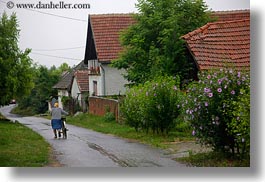 images/Europe/Hungary/TokajHills/Misc/woman-pushing-bike-by-houses.jpg