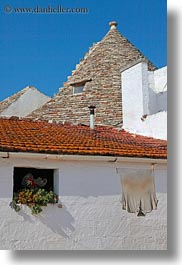 alberobello, buildings, europe, farm house, flowers, hangings, italy, puglia, shirts, structures, trullis, vertical, photograph