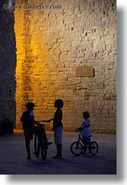 bicycles, castles, childrens, europe, evening, italy, otranto, people, puglia, vertical, photograph