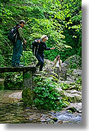 europe, hikers, hiking, jenna, jim, kozjak, leaves, lush, men, slovenia, stream, vertical, walking plank, womens, photograph