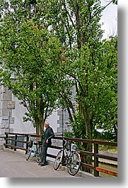 bicycles, europe, ljubljana, men, people, slovenia, trees, vertical, photograph